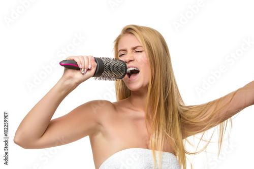 Happy woman in towel singing using comb 