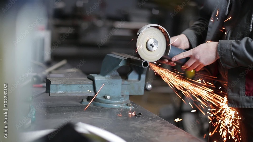 Man sawing metal by grinder, filmed with a slider