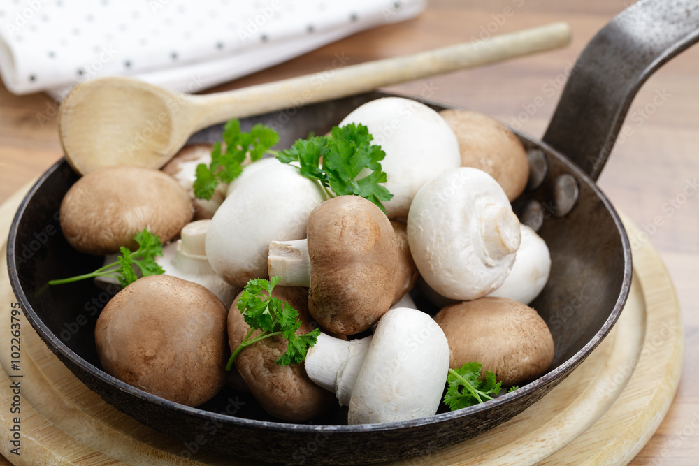 Frische rohe Champignons in einer Eisenpfanne Frische rohe Champignons in einer Eisenpfanne