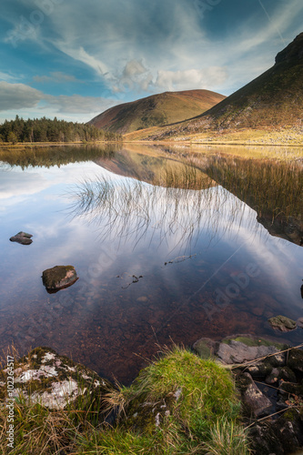 Wild landscape Lake reflection of Glentenassig Woods and Lake in north Kerry, Ireland photo