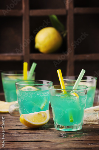 Green cocktail with lemon and ice on the wooden table