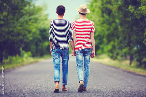 gay couple walking away together on spring road photo