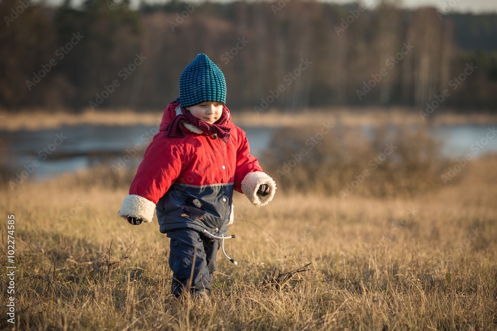 Young happy boy playing outdoor in spring landscape near lake Young happy boy playing outdoor in spring landscape near lake
