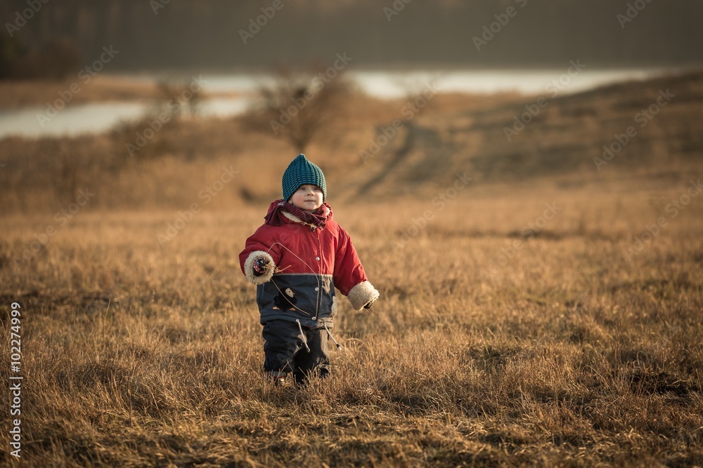 Young happy boy playing outdoor in spring landscape near lake Young happy boy playing outdoor in spring landscape near lake