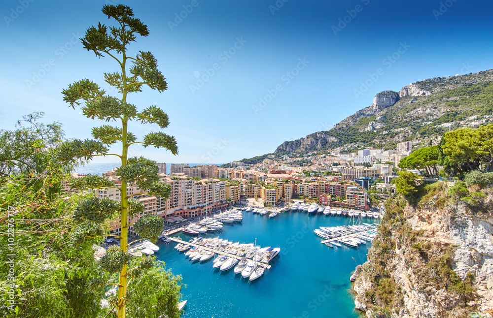 Monaco, Fontvieille, 29.08.2015: Port Fontvieille, panorama, topview from Monaco Ville, azur water, sun reflections on the water, harbor, sunny day, luxury apartments, yachts, rocks