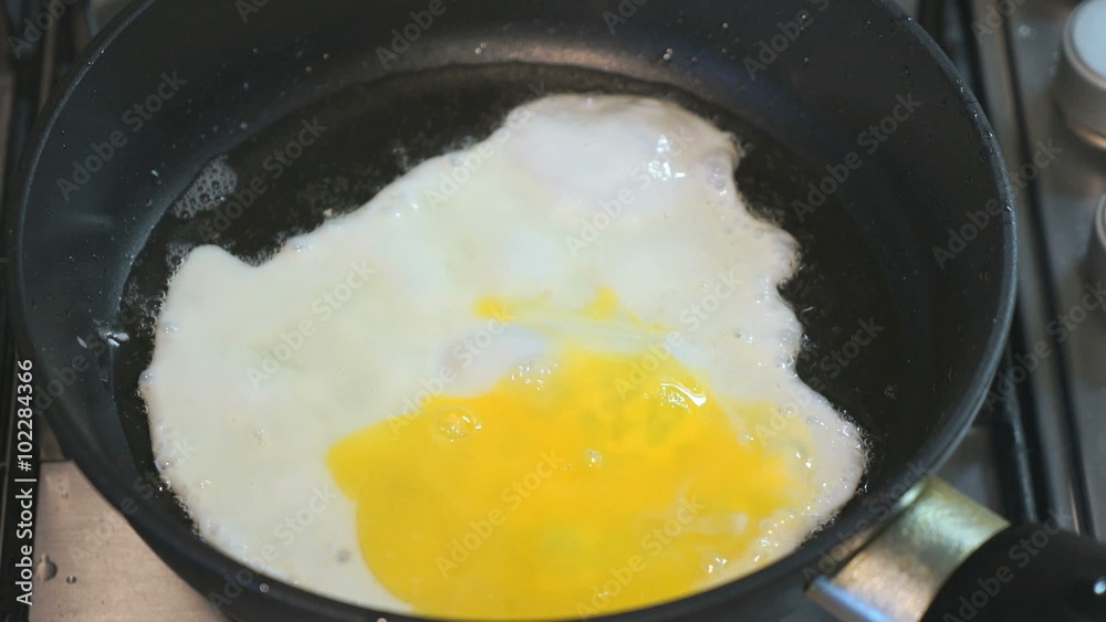 The process of frying eggs in a skillet. Skillet stands on the hob. Closeup The process of frying eggs in a skillet. Skillet stands on the hob. Closeup