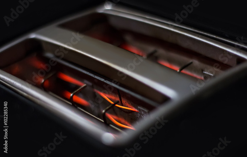 Glowing resistances inside black toaster photo