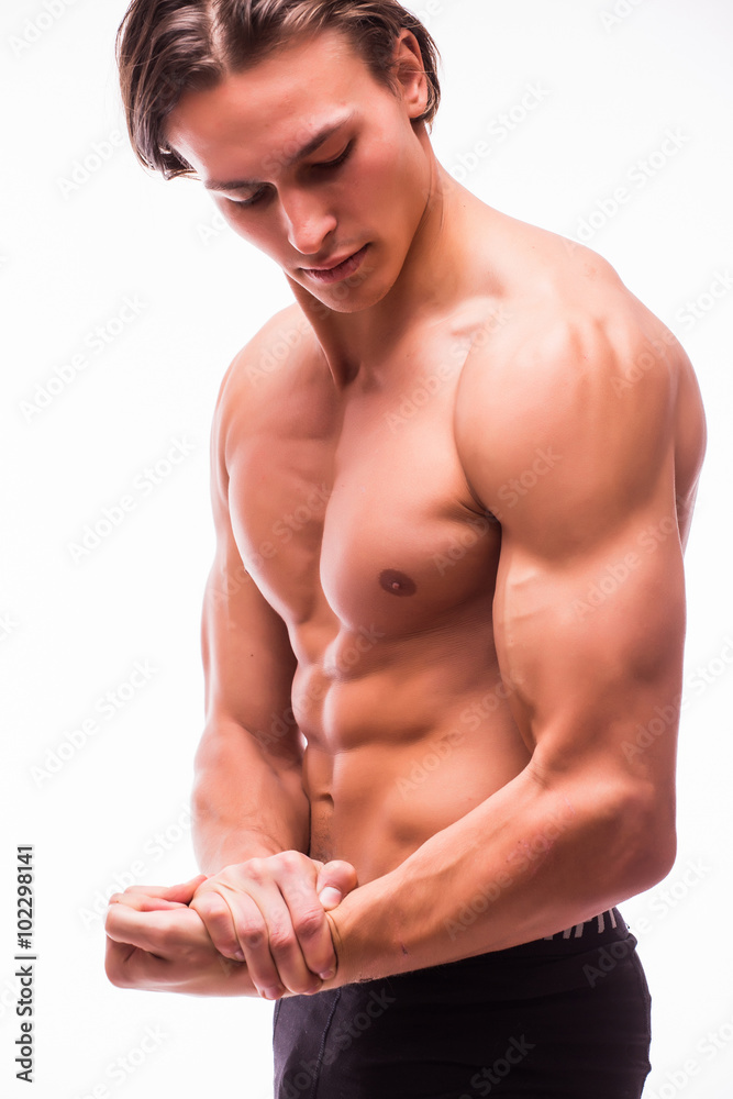 Handsome muscular young man looking sideways posing at studio on a white background