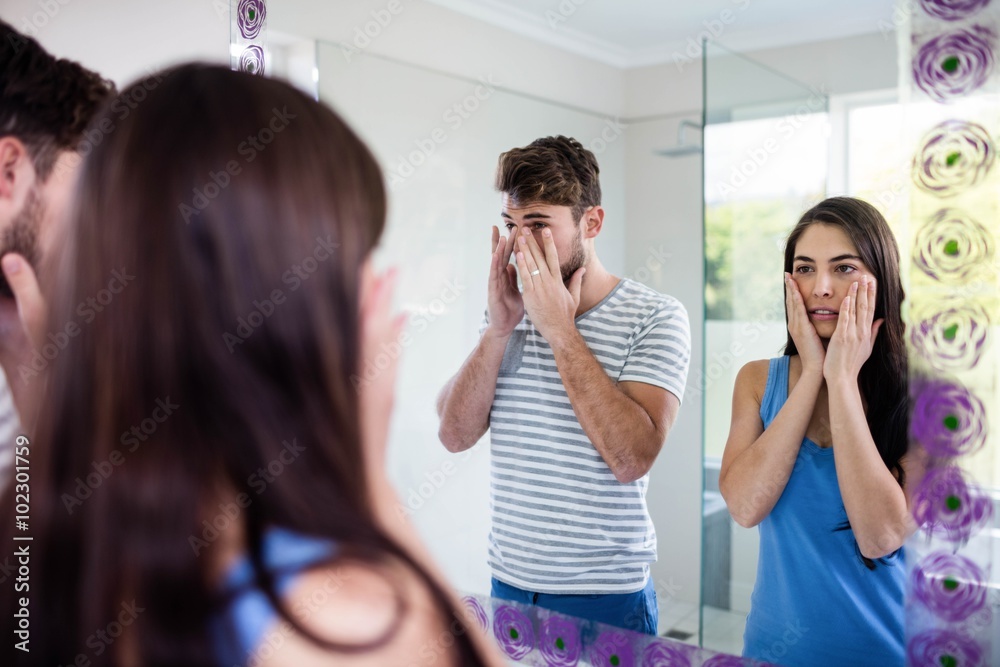 Couple looking themselves in the mirror Couple looking themselves in the mirror