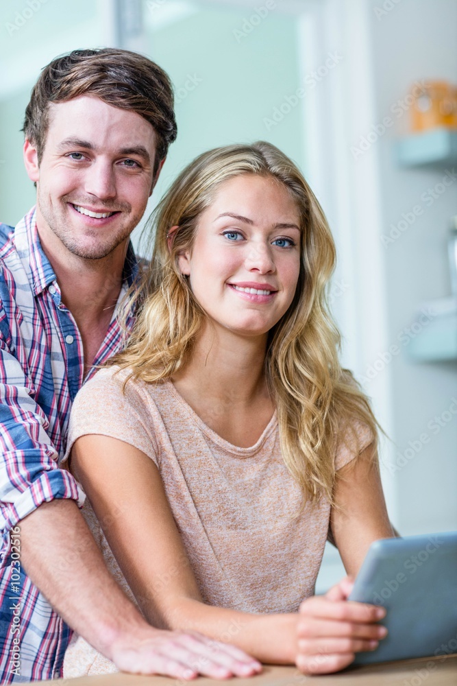 Cute couple using tablet computer in the kitchen Cute couple using tablet computer in the kitchen
