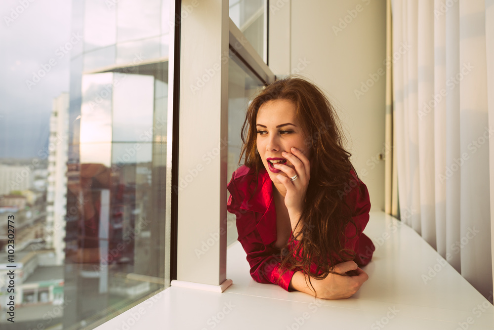 Beautiful female having fun relaxing looking out the window, portrait