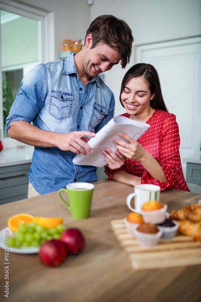 Happy couple having breakfast and reading newspaper Happy couple having breakfast and reading newspaper