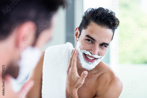Handsome man shaving his beard photo