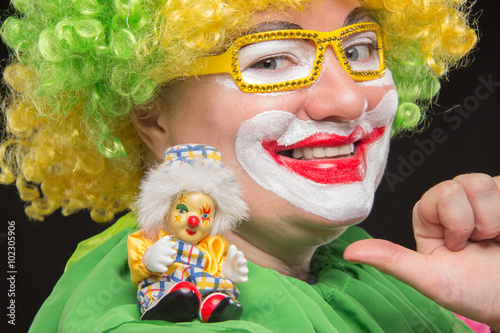 Good fun curly clown holding a beautiful little toy clown
