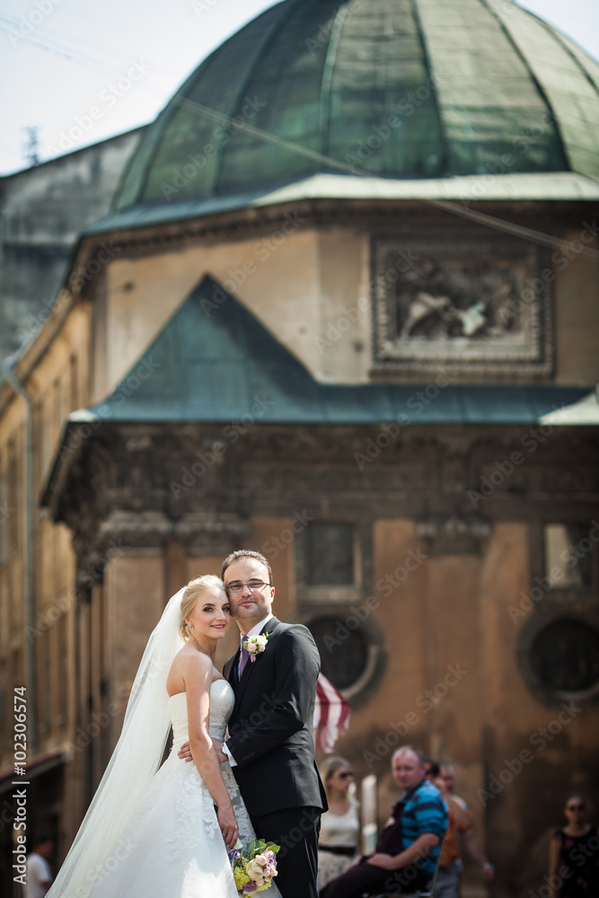 Sensual romantic couple of newlyweds hugging in front of old chu