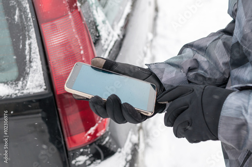 Driver calling with phone for help on the road in winter