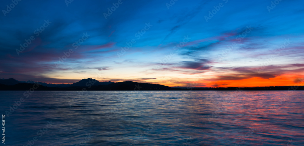 Night Panorama. Dramatic sunset over the lake in the Swiss Alps. Canton Zug. In the background the mountains silhouettes. High Dynamic Range Image