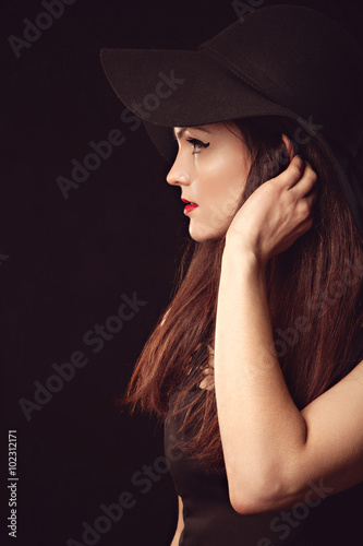 Graceful woman in elegant black hat with wide brim