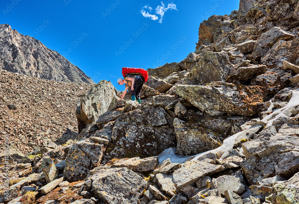 Hiking. Woman with a backpack gently descends