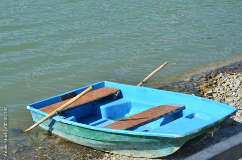 Old wooden boat for water walks on the pebbled shore of a mountain lake © Alexandrova Elena