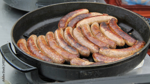 A Pan of Thick Sausages Cooking on a Stove.