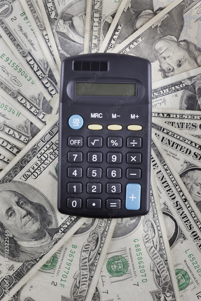calculator on the background of american dollars banknotes calculator on the background of american dollars banknotes