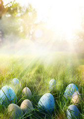 art Colorful Easter eggs in the grass on sky background