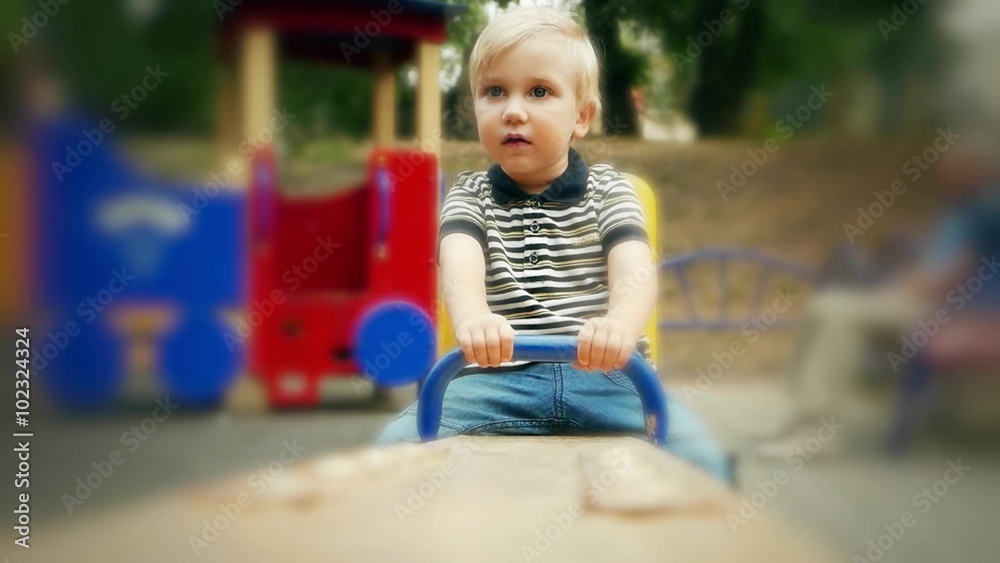 Children's dreams, memories. Sad child baby toddler boy on the swings in playground. Loneliness, kid Children's dreams, memories. Sad child baby toddler boy on the swings in playground. Loneliness, kid