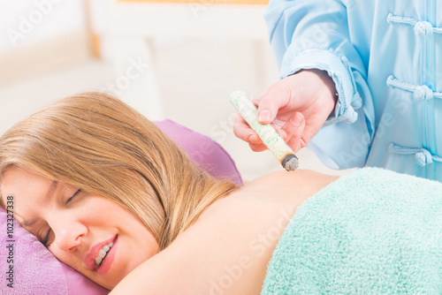 Alternative medicine therapist doing moxa treatment