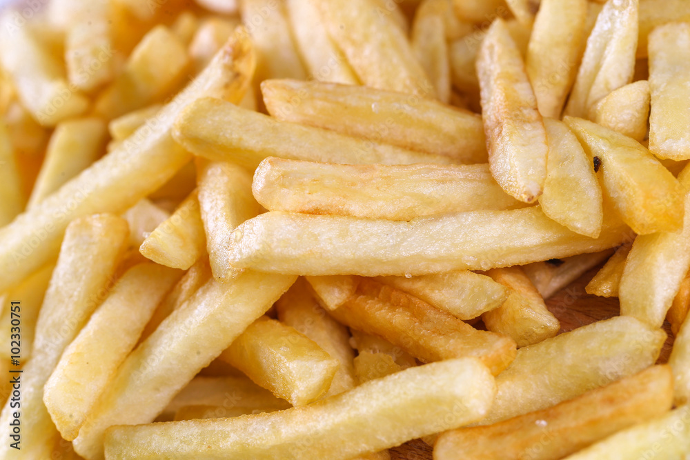 Tasty french fried potatoes on a wooden plate Tasty french fried potatoes on a wooden plate