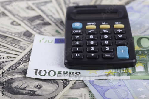 calculator, banknotes of dollars and euro background