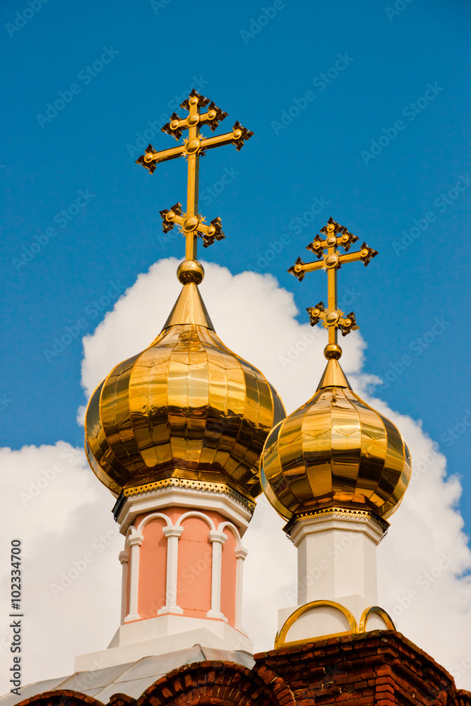 Two golden domes of the Orthodox Christian Church against the cloudy sky