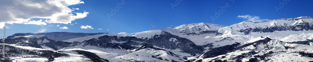 Panoramic view on snowy mountains at nice sun day