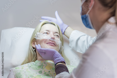 Doctor examining a happy patient after procedure