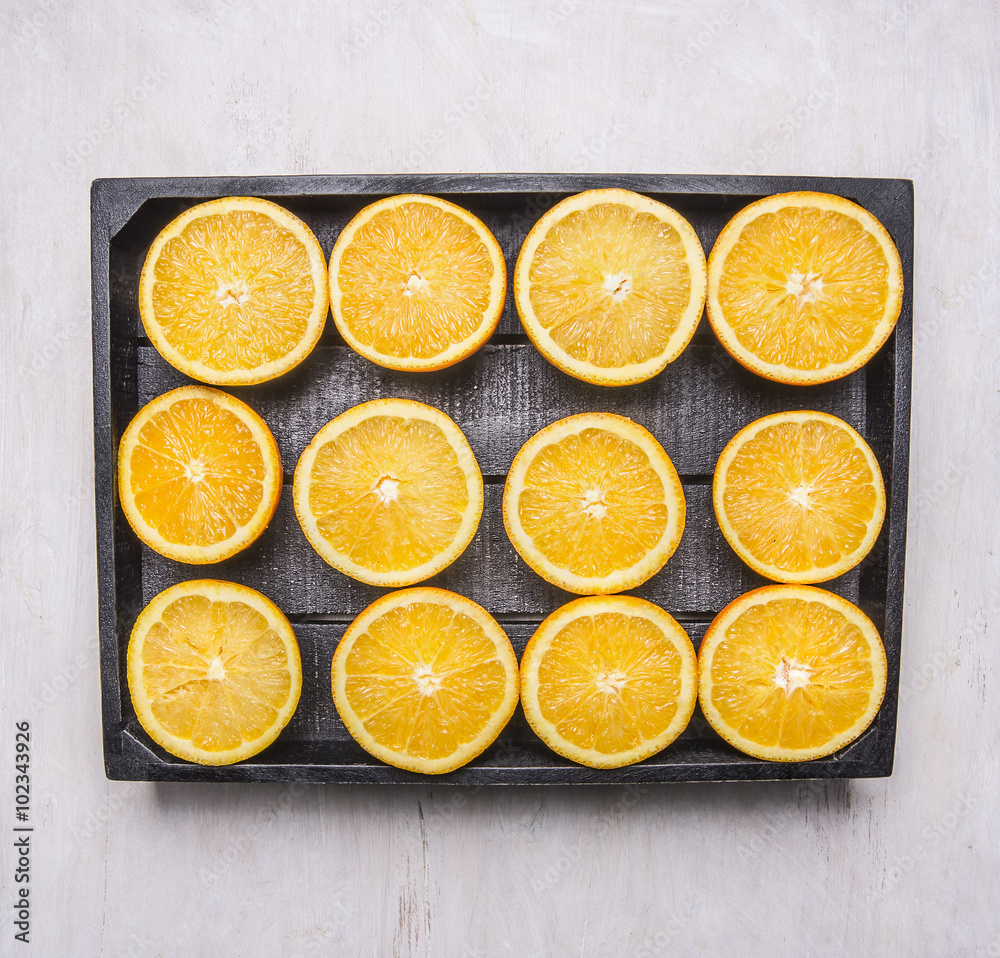 cut oranges in a black wooden box on wooden rustic background top view close up cut oranges in a black wooden box on wooden rustic background top view close up