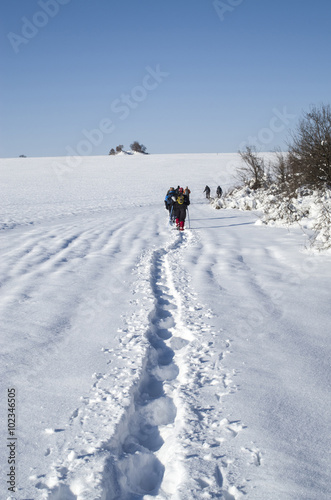 Men hiking in winter on a snow trail