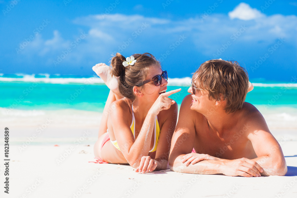 happy romantic young couple lying at a tropical beach happy romantic young couple lying at a tropical beach