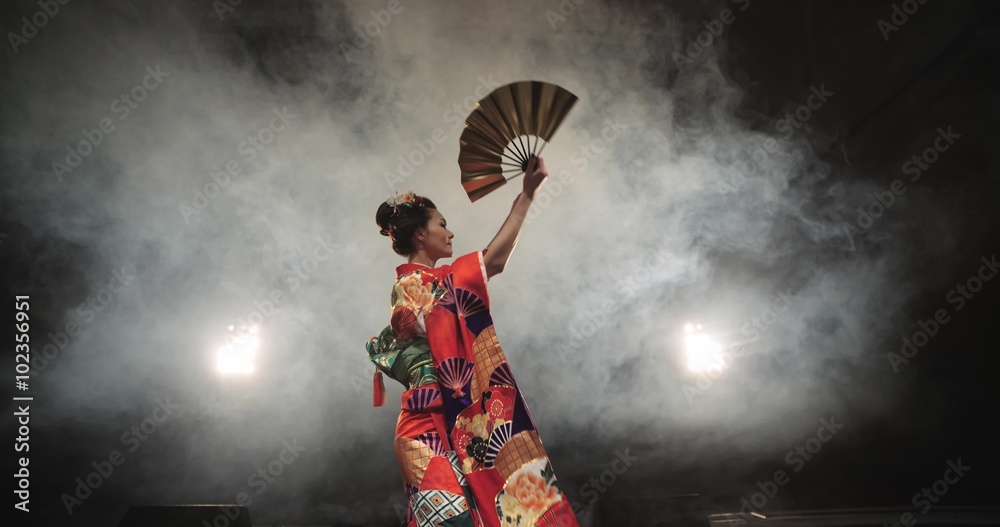 4K beautiful Japanese geisha dancing on stage and posing for the camera,the smoke in the background, slow motion