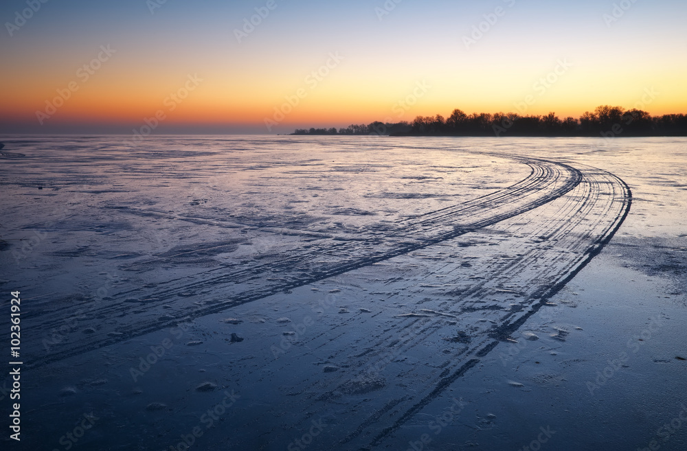 Trails on the surface of frozen lake. 