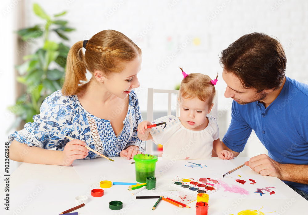 happy family: mother, father and child daughter draw paints happy family: mother, father and child daughter draw paints