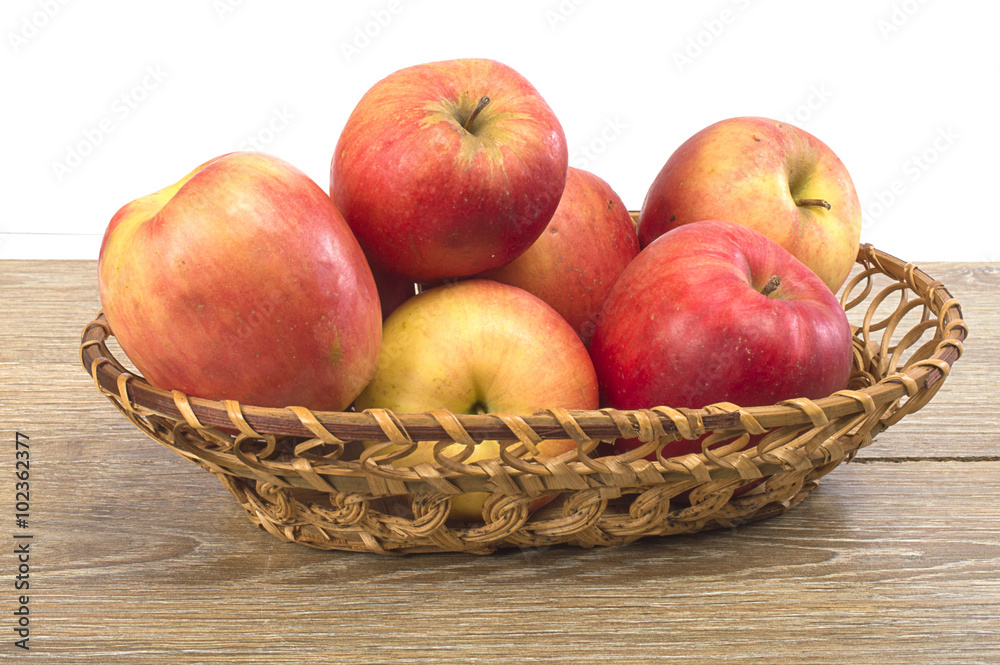 apples in a basket on a wooden background apples in a basket on a wooden background