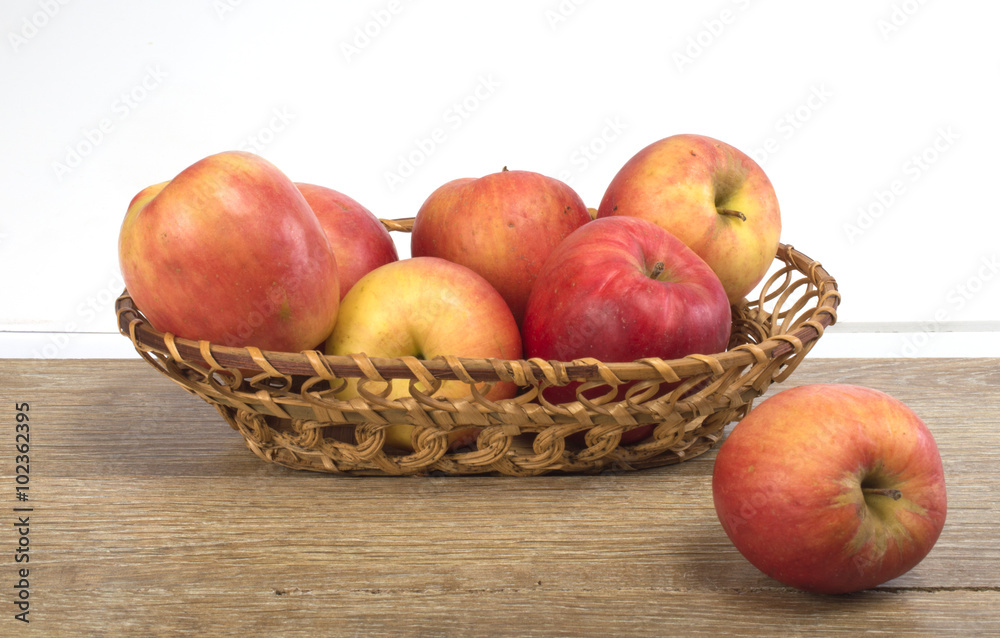apples in a basket on a wooden background apples in a basket on a wooden background