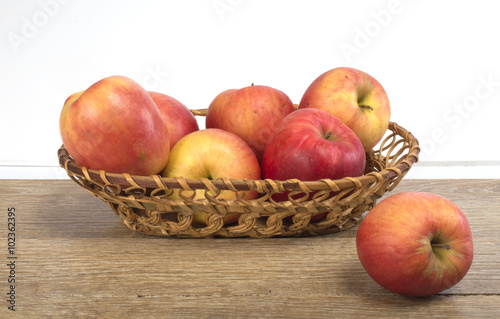 apples in a basket on a wooden background