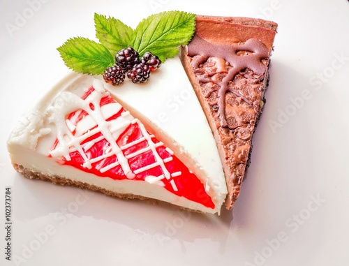 Raspberry, Plain And Chocolate Cheesecake. Cheesecake sampler on a white background garnished with fresh fruit.