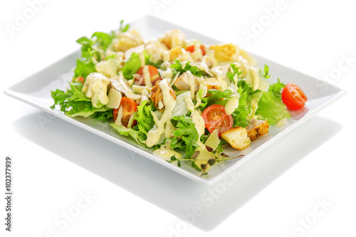 Isolated delicious ceasar salad on a white plate with a white background