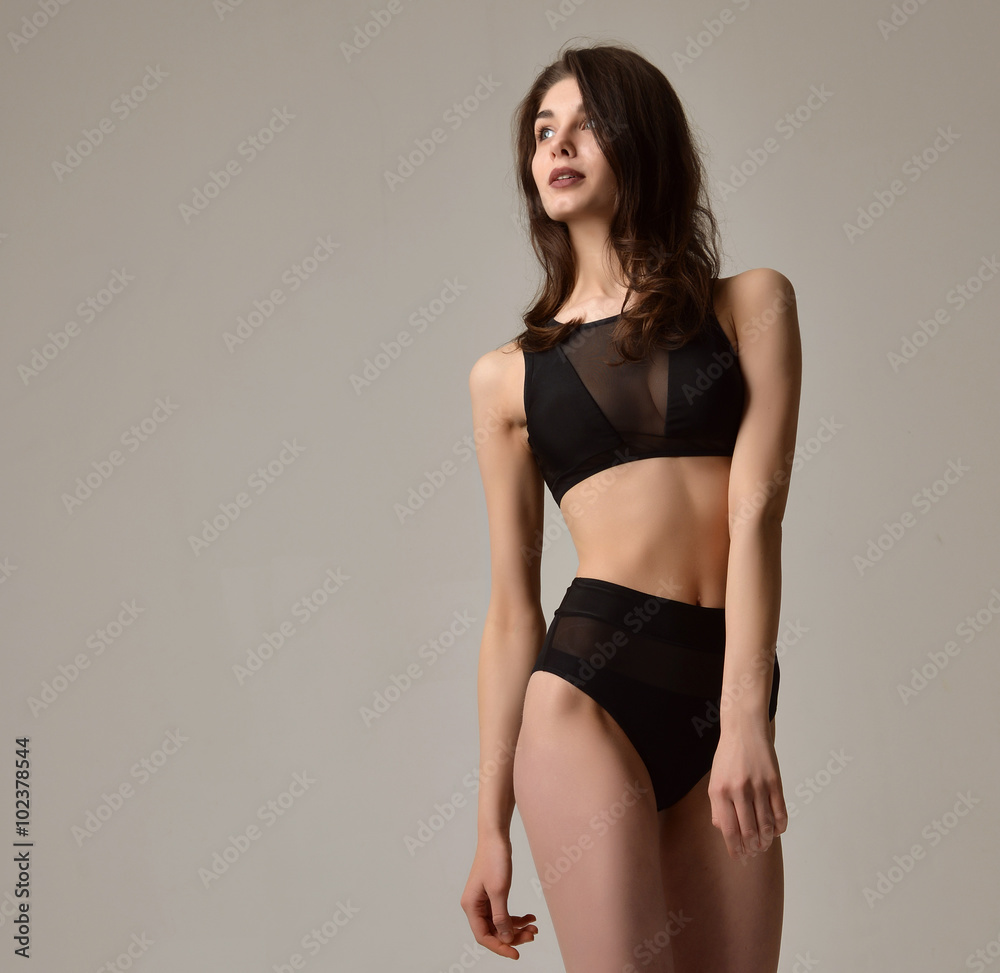 Sexy young beautiful woman posing in black modern bikini underwe