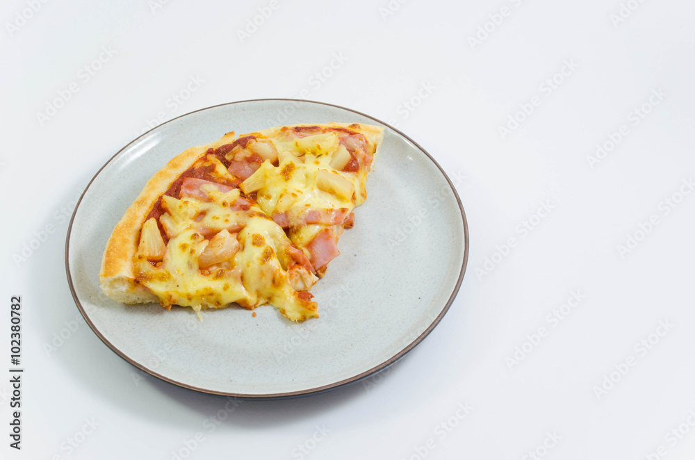 Slice of pineapple and ham pizzas on the plate