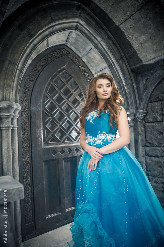 Fototapeta premium Princess in blue dress is going to open the castle door.
