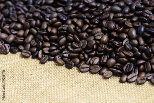 Closeup of roasted coffee bean on sack backgound.