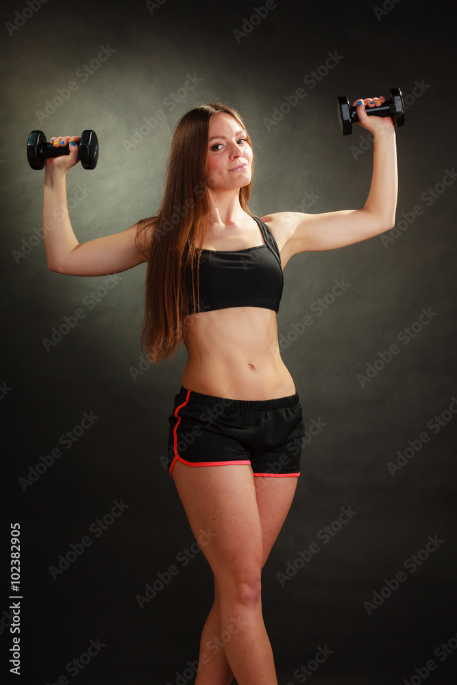 Fit woman exercising with dumbbells.